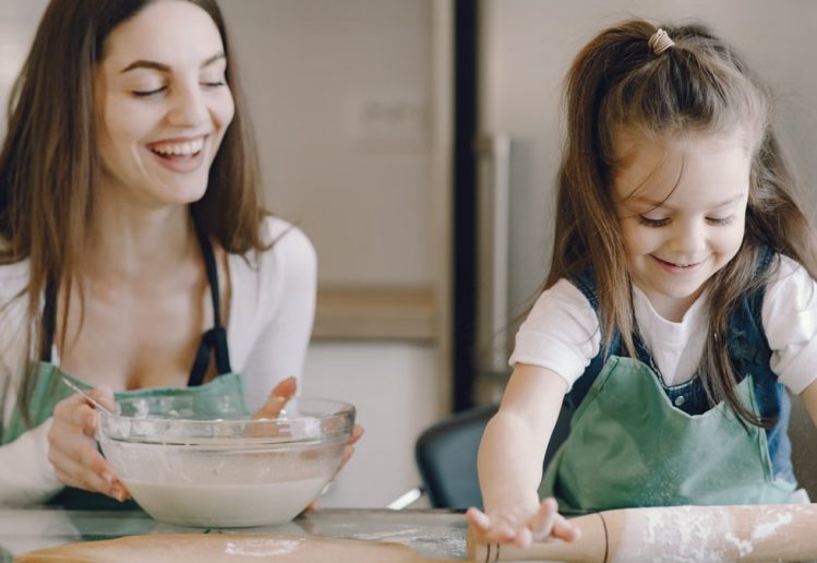 A joyful moment as a mother and daughter bond while baking pastries at home.