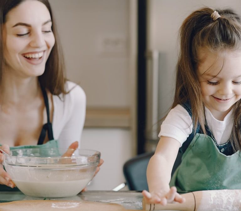 A joyful moment as a mother and daughter bond while baking pastries at home.